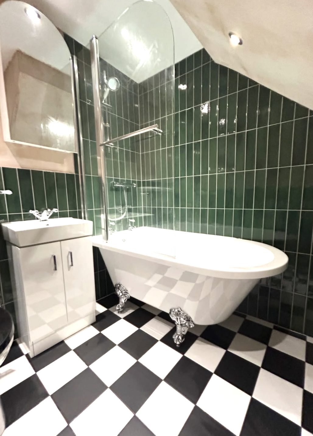 Green vertical metro tiled bathroom with roll top bath and chequerboard floor