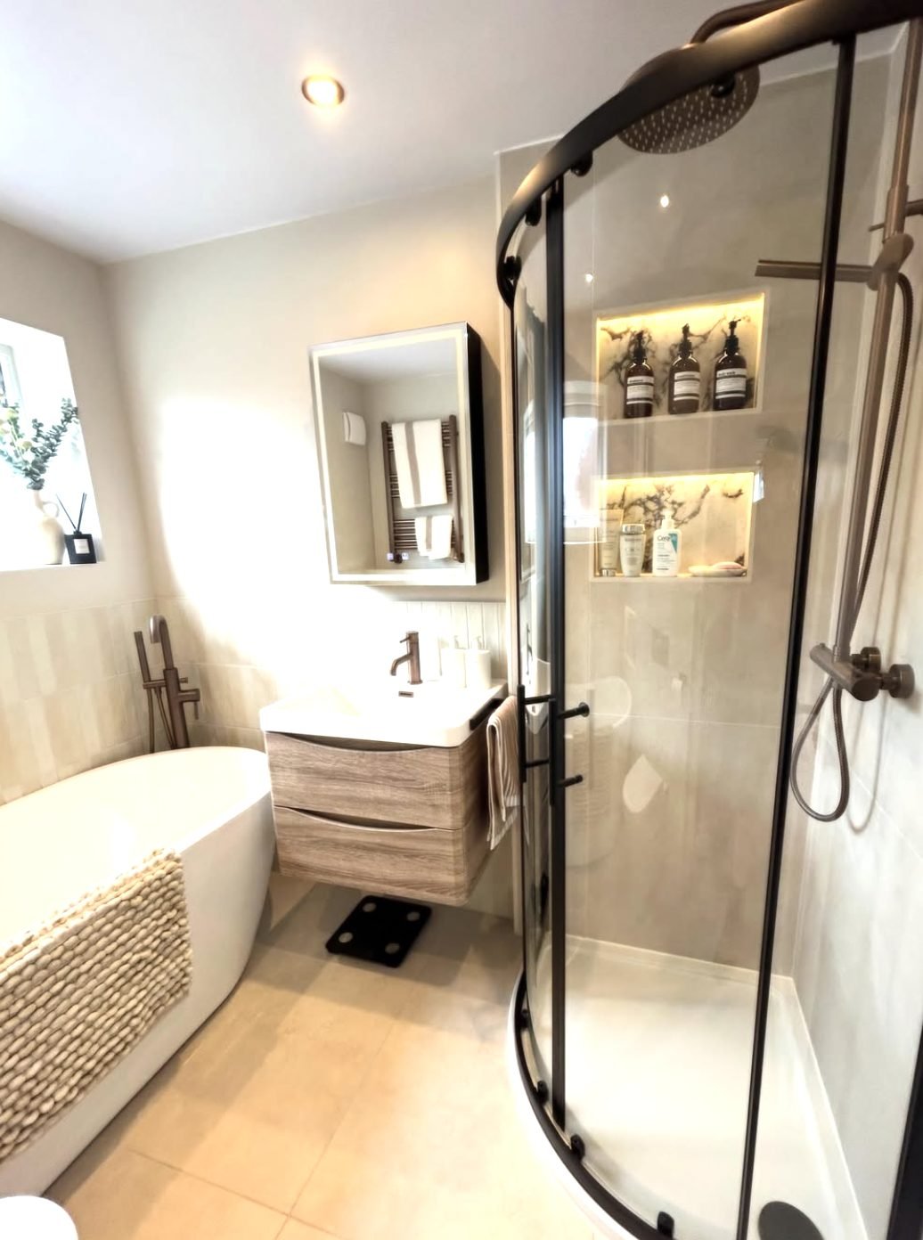 Warm neutral bathroom with freestanding bath and quadrant shower enclosure